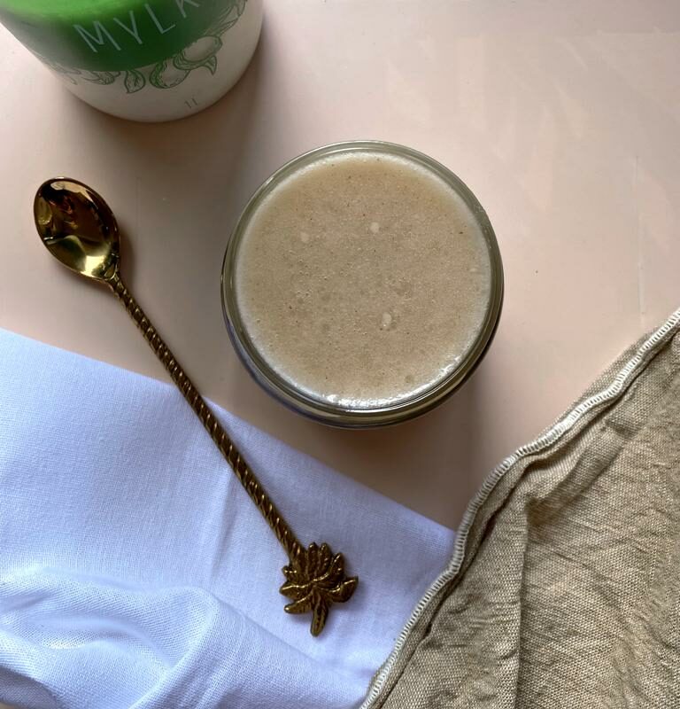 Jar of condensed milk next to a jug of plant milk