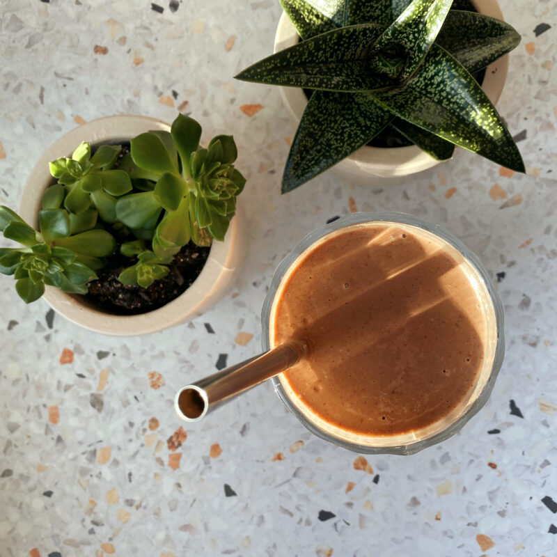 Over the top shot of the chocolate caramel smoothie with a straw in a glass