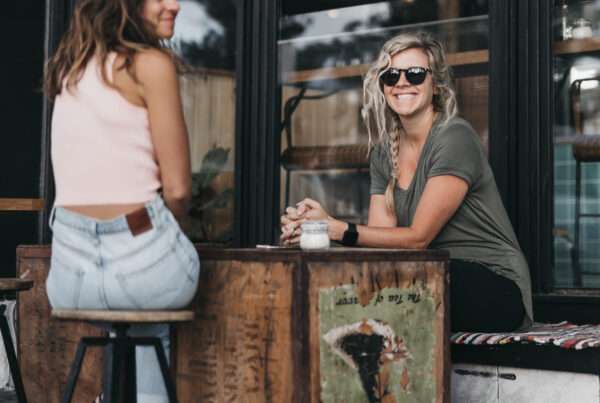 Vasia and Heidi sitting down at a cafe smiling