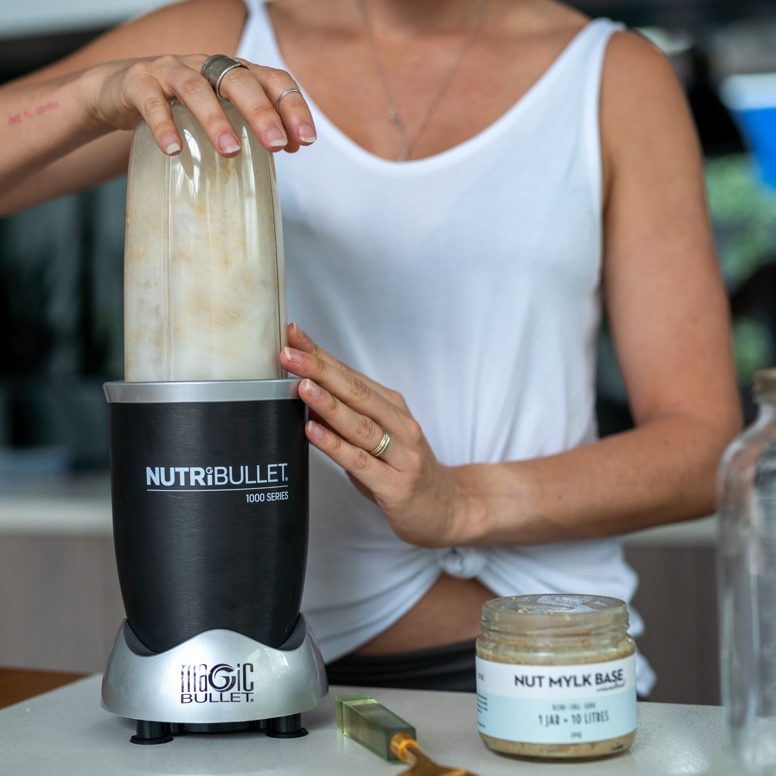 Woman blending Nut Mylk Base in a NutriBullet