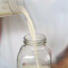 Pouring freshly made milk into a glass bottle