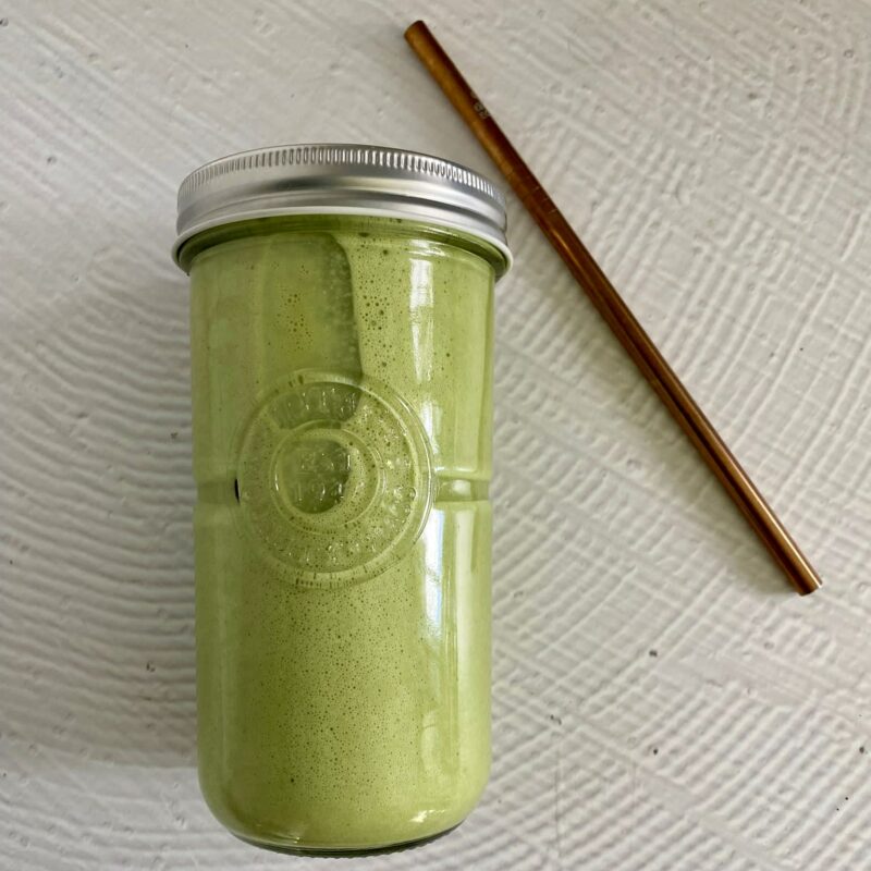 Green Smoothie in a glass jar and reusable straw on the right hand side